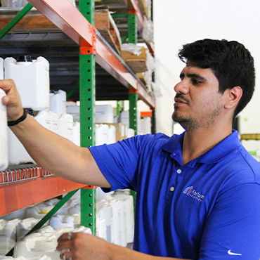 man in blue polo shirt picking a product from a shelf
