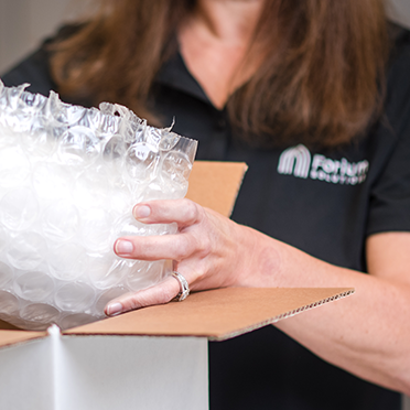 Forium Solutions employee owner packing a sample in box