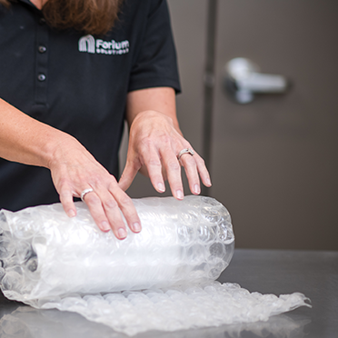 Forium Solutions employee owner packing a sample